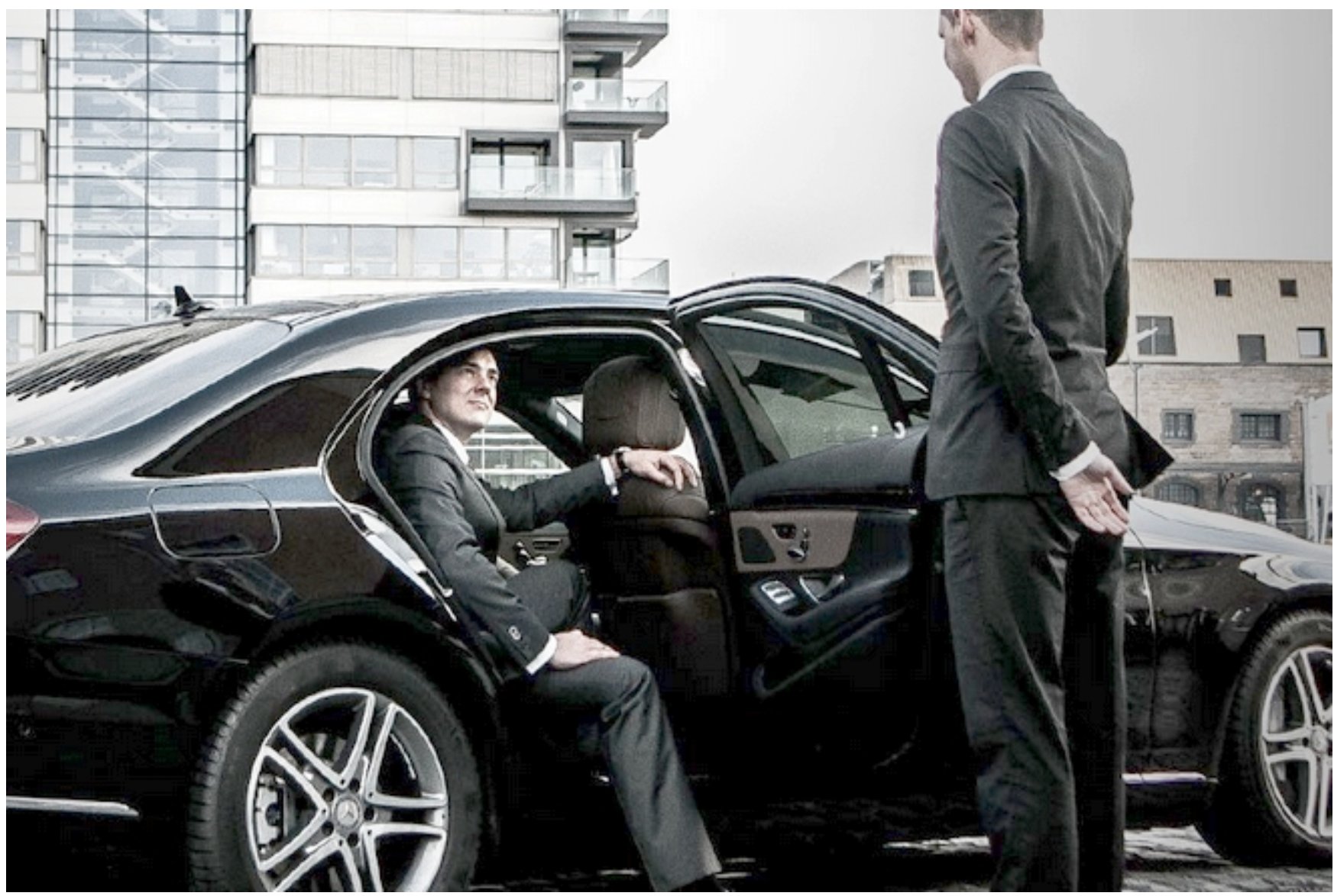 Chauffeur opening car door for client