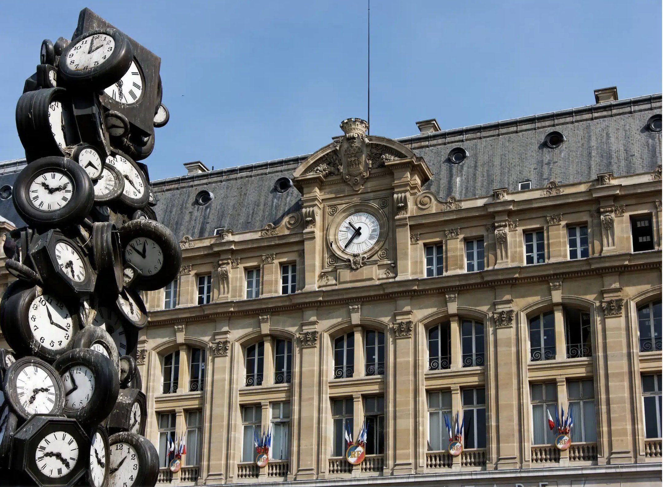 Fa&ccedil;ade haussmannienne de la Gare Saint-Lazare &agrave; Paris avec sa tour horloge et la sculpture d'Arman &laquo; L'Heure de tous &raquo;